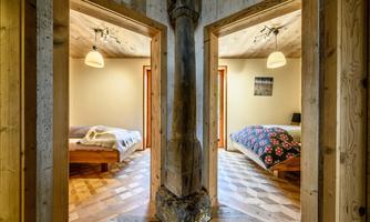 Two cozy bedrooms with wooden interiors and soft beds. The room is brightly lit and exudes an inviting atmosphere.