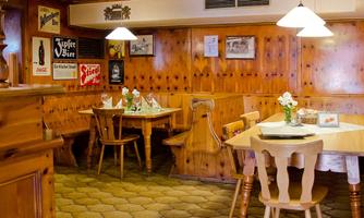 A cozy tavern with wooden-paneled walls and rustic tables. Soft lighting creates an inviting atmosphere.