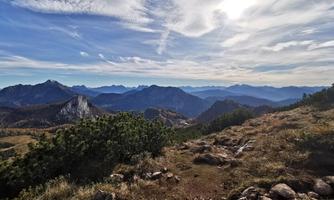 A fascinating mountain landscape with gentle hills and broad views. A clear sky and the sun shining over the peaks.