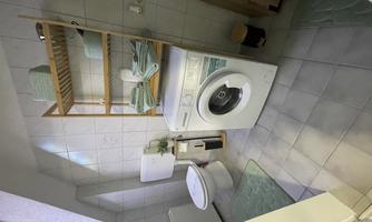 A modern bathroom with a washing machine, a toilet, and a wooden shelf. It is bright and well-organized, with towels and a decorative plant.