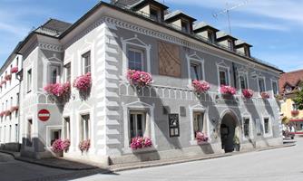 A beautiful, historic building with a decorative facade and colorful flower boxes. The architecture is appealing and exudes an inviting atmosphere.