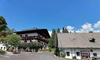 A picturesque Alpine house with a balcony and flowers. The radiant blue sky complements the idyllic landscape.