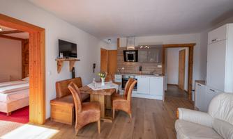 A modern apartment with a cozy living and dining area. The décor is bright and inviting, perfect for a relaxing stay.