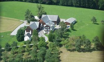 A rural complex with several buildings and plenty of greenery. Surrounded by meadows and trees, the area provides a tranquil atmosphere.