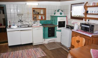 A cozy kitchen with a traditional oven and modern appliances. The room has wooden floors and is bright and inviting.