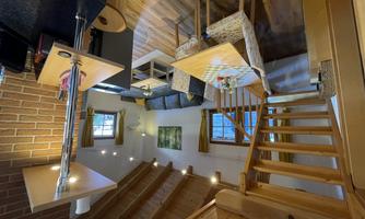 A bright and inviting living kitchen with wooden furniture and a cozy seating area. The stairs lead to an upper area that offers additional living space.