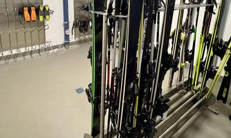 A room with ski storage. Several skis and a helmet are neatly arranged.