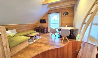 A cozy room with wood paneling, a sofa, and a dining area. Large windows provide plenty of light and an inviting atmosphere.