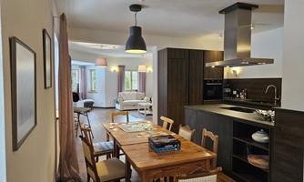 A bright and modern kitchen with a large dining table. The open living area is cozy and invitingly designed.