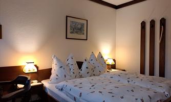 A cozy bedroom with a double bed and decorative pillows. Soft light from bedside lamps and a relaxed atmosphere invite you to unwind.