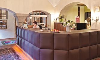 An elegant reception desk in a stylish hotel. The room is bright and inviting, with beautiful decorations and plants.