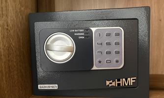 A secure wall safe with digital keys and a rotating mechanism. It displays a warning message for weak batteries.