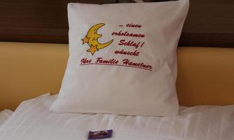 A pillow with a print showing a moon and stars. Beneath it is the wish for a restful sleep from the Hameter family.