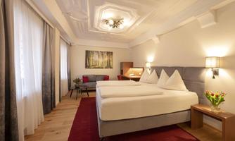 A modern room with two single beds and elegant furnishings. Large windows provide plenty of daylight and a cozy atmosphere.