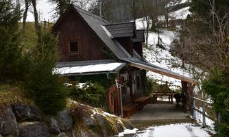 A cozy wooden house in a snowy landscape. Surrounded by trees and a tranquil environment.