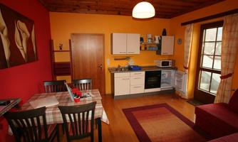 A cozy kitchen with a dining area and modern appliances. The walls are painted in warm colors, creating an inviting atmosphere.