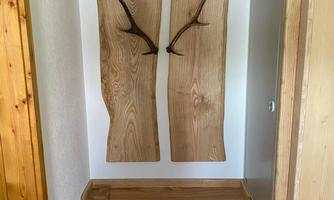 A simple hallway with wooden shelves and a wall coat rack. The furniture is made of light wood and creates a cozy atmosphere.