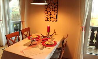 A beautifully set table in a cozy dining area. A candle and wooden decoration create a warm atmosphere.