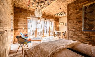 A cozy room with wooden walls and a window that lets in plenty of light. The decor is modern and inviting with stylish furniture.