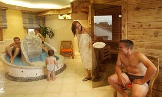 A relaxing wellness area with a sauna and a small pool. A family enjoys their time together in a calm atmosphere.