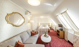 A cozy room with a bright sofa and elegant decorations. The windows let in plenty of light and create an inviting atmosphere.