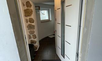 A modern front door with a clear design. The hallway behind it is bright and inviting.