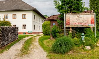 A charming building with a green driveway. Next to the path is a sign that reads "Gaferhelm".