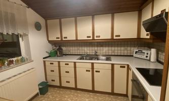 A modern kitchen with bright cabinets and a large countertop. The decor is functional and tidy.