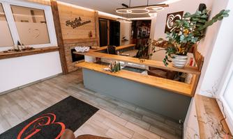 An inviting reception area with modern design. The combination of wood and plants creates a cozy atmosphere.