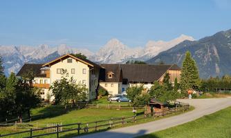 A cozy house in the mountains with a beautiful view of the peaks. The landscape is green and peaceful, ideal for a stay in nature.