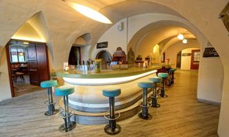 A modern, elegant café with a curved counter and stylish bar stools. The space has a pleasant atmosphere with soft lighting and curved arches.