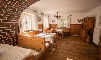 A cozy room with wood paneling and rustic furniture. There are tables and benches that invite you to linger.