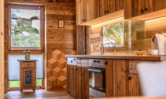 A modern kitchen made of wood with bright surfaces and a clear, inviting atmosphere. The room features large windows and an appealing decor.