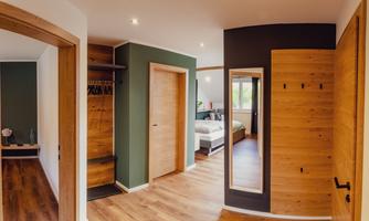 A modern room with wooden details and clean lines. In the background, a bed is visible, creating a cozy atmosphere.