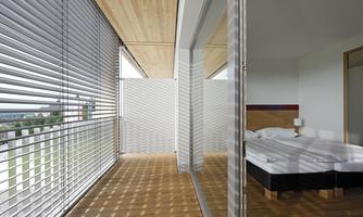 A modern bedroom with large windows and wooden blinds. The room has a minimalist style with a double bed and a beautiful view outside.