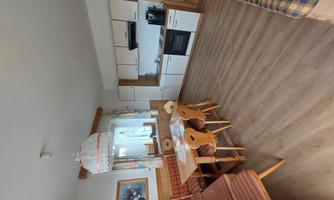 An inviting kitchen with a dining table and chairs. The decor is bright and modern, with a window that lets in plenty of daylight.