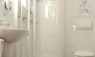 A modern bathroom with a shower, sink, and toilet. The walls are light tiled and there are decorative elements.