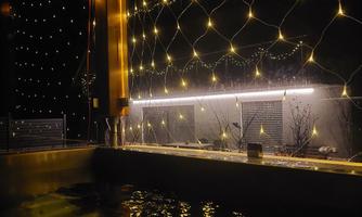 A relaxing pool at night, surrounded by sparkling lights. The warm lights create a cozy atmosphere.