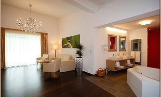 A modern room with a stylish living area and a bathroom. Large windows provide plenty of daylight and a pleasant atmosphere.