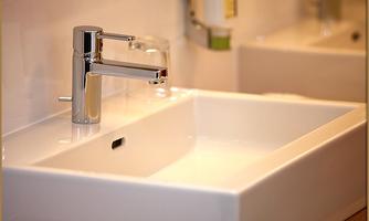 A modern sink with a shiny faucet. The surroundings appear clean and tidy.