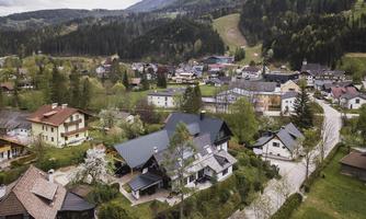 A picturesque village in the mountains with green forests and modern as well as traditional houses. The tranquil surroundings invite relaxation.