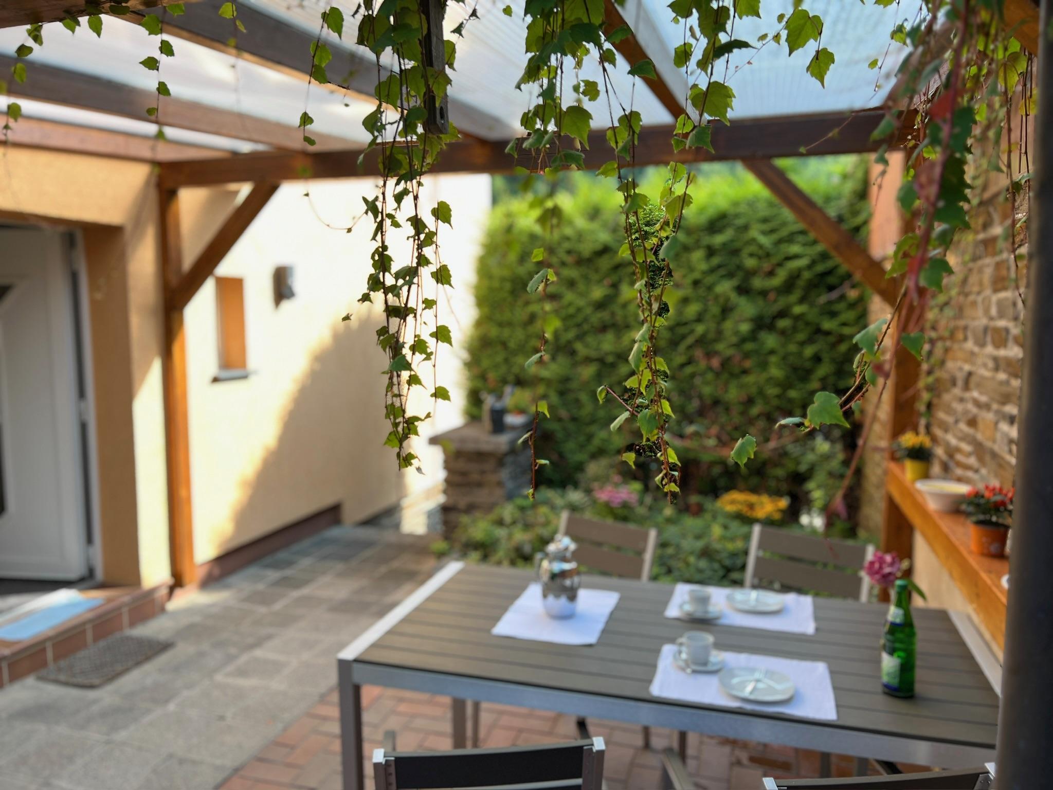 Überdachte Terrasse mit Tisch und 4 Stühlen