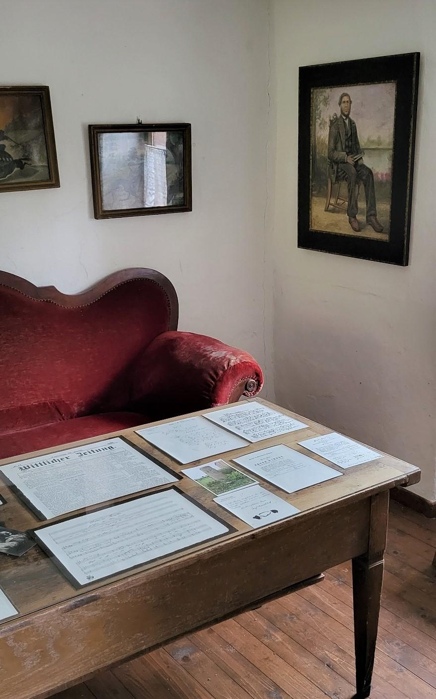 Rotes Sofa mit Bild des Dichters