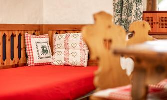 A cozy seating area with red cushions and wood paneling. The curtains enhance the homey atmosphere.