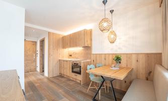 Modern kitchen with wooden elements and a cozy dining area. The warm colors create an inviting atmosphere.