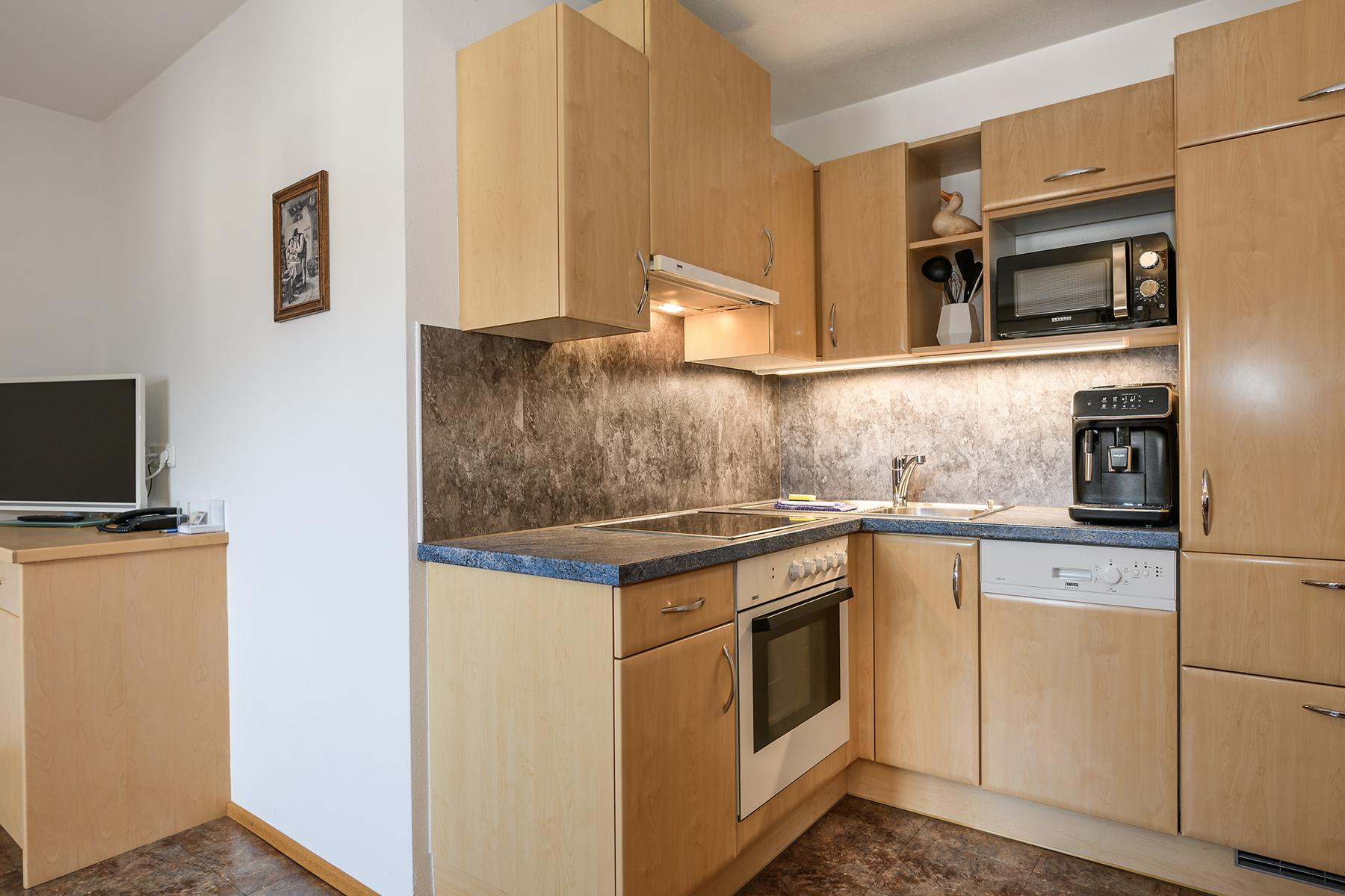 A modern kitchen with wooden furniture and a complete set of appliances. It is designed to be bright and functional. Hiking trails, ski lifts, and the swimming pool are just a few meters away.