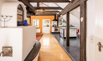 An inviting kitchen with wooden ceilings and a warm color scheme. The room is bright and spacious, with an open design.