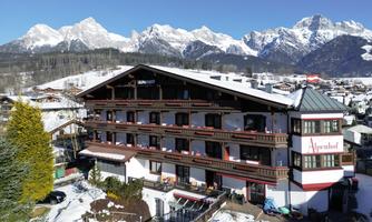 A stylish hotel in the mountains, surrounded by snow-covered landscapes. The majestic mountains create an impressive backdrop.
