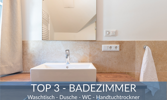 A modern bathroom with a sink on a wooden surface and a large mirror. The walls are bright and the lighting is inviting.
