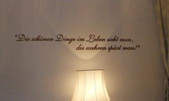 A wall quote in elegant script about beautiful things in life. In the foreground, a lamp with an attractive shade glows.